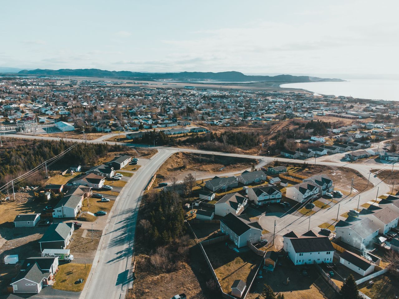 Crafting Captivating Headlines: Your awesome post title goes here Drone view of coastal settlement with small houses and asphalt road near sea and mountain on background under light blue sky on sunny day in autumn